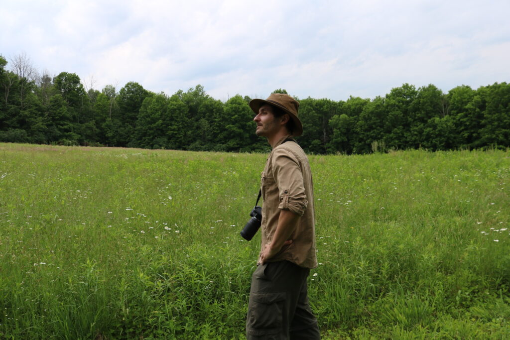 Sam Quinn standing in a meadow.